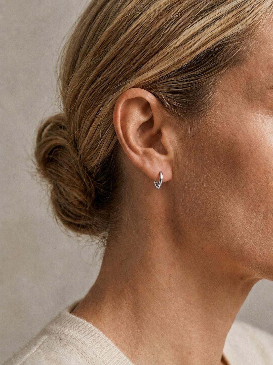 Model wearing 8.8mm PT950 teardrop huggie earrings in profile