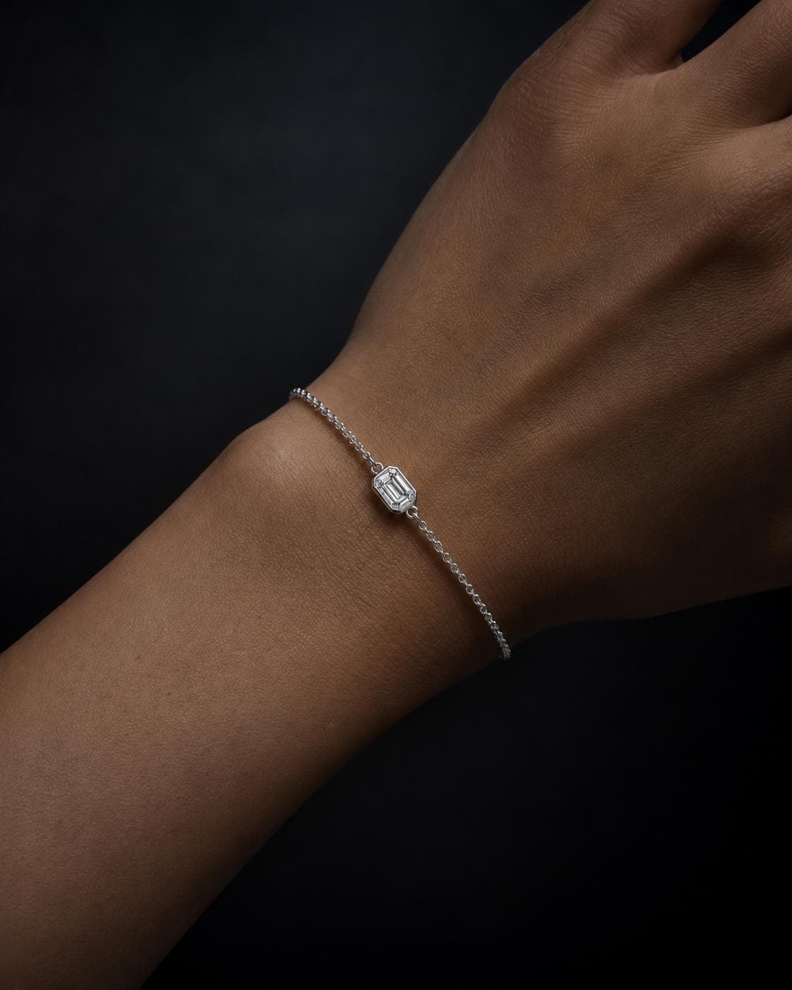Woman wearing emerald-cut lab diamond platinum bracelet
