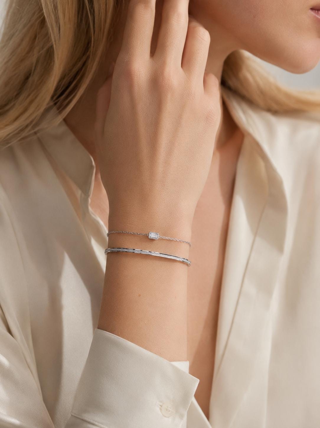 Frosted platinum bangle layered with fine bracelet