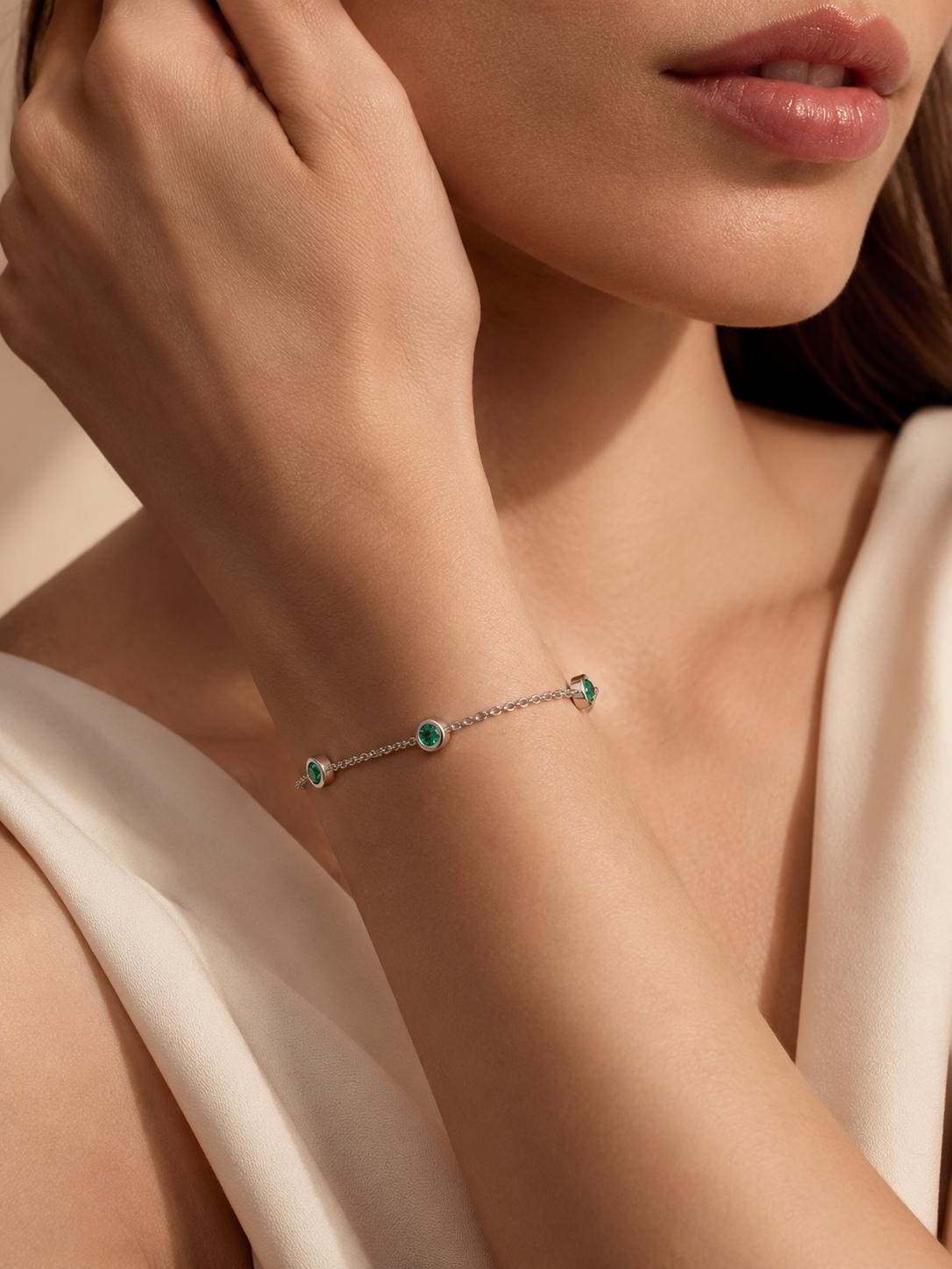 Close wrist view of bezel-set natural emerald bracelet