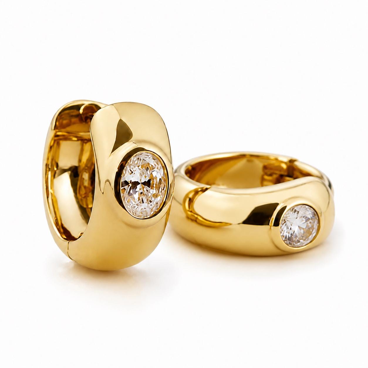 Angled pair of chunky 18K gold oval diamond huggie hoops