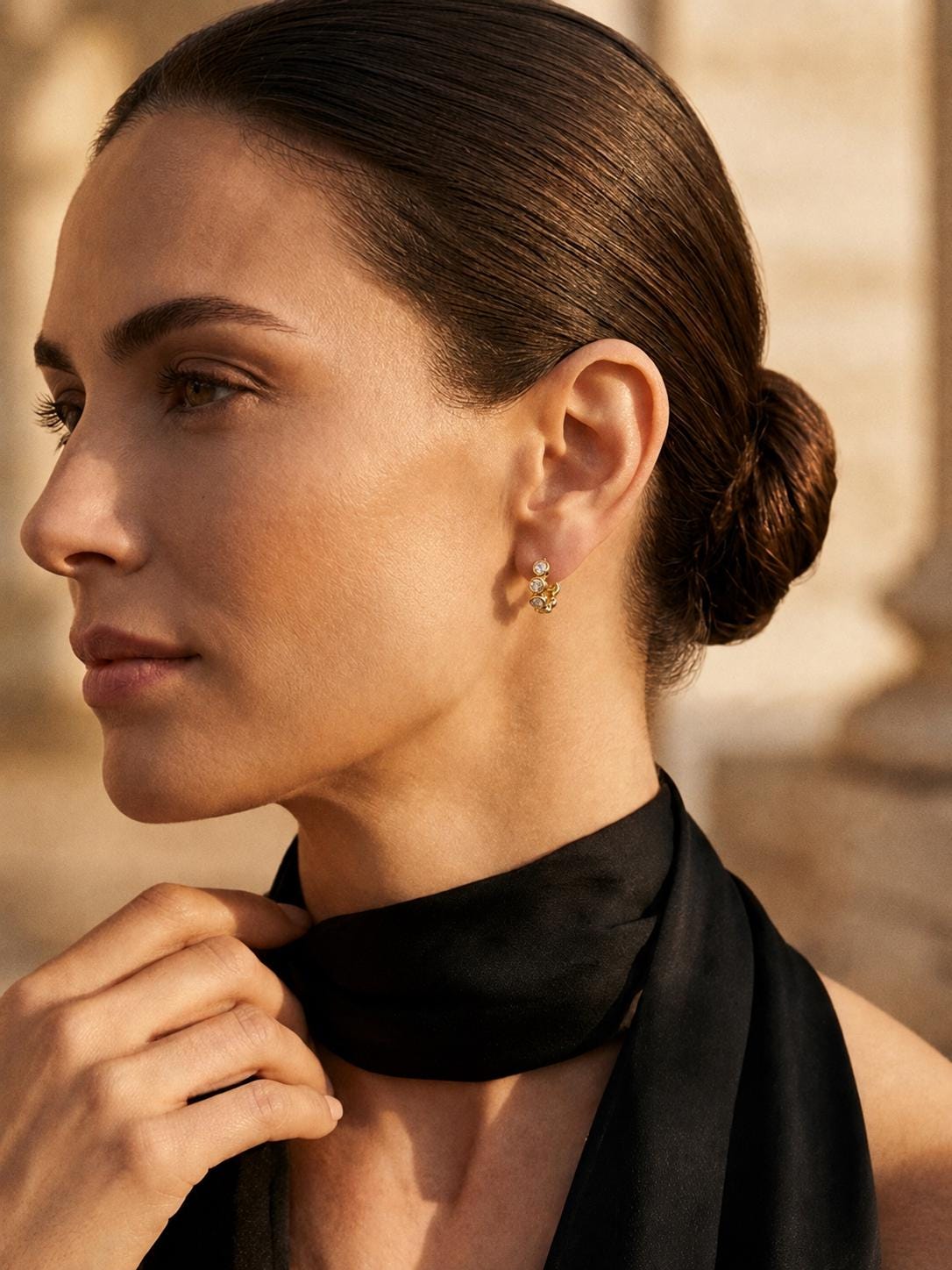 Model wearing 18K gold lab diamond huggie earrings in profile