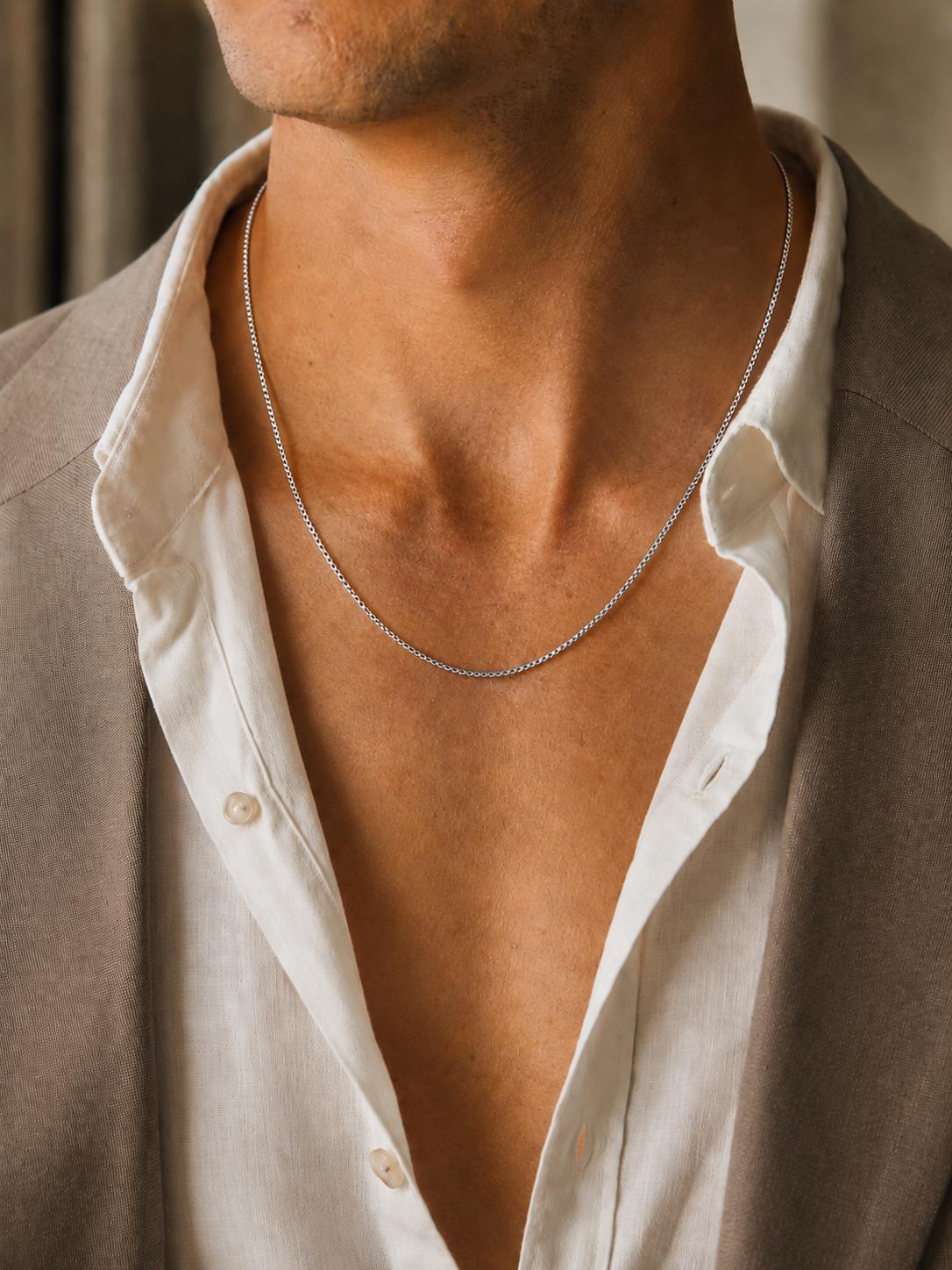 Man wearing 1.7mm platinum Venetian box chain with beige blazer