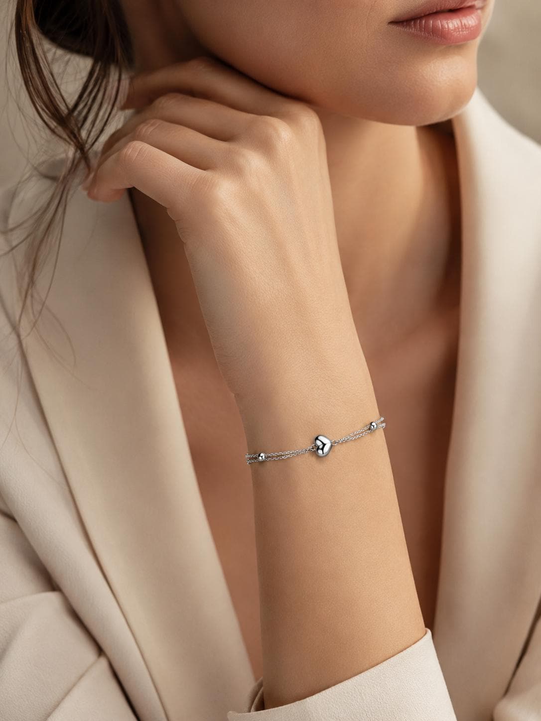Close wrist view of double-chain platinum heart bracelet