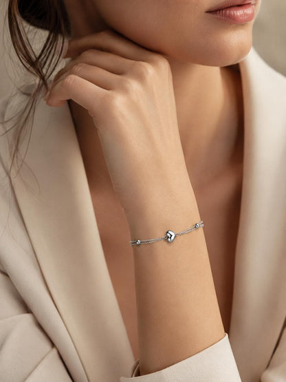 Close wrist view of double-chain platinum heart bracelet
