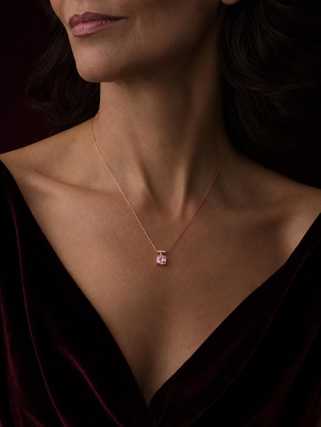 Woman wearing 18K rose gold pink diamond necklace with burgundy V-neck
