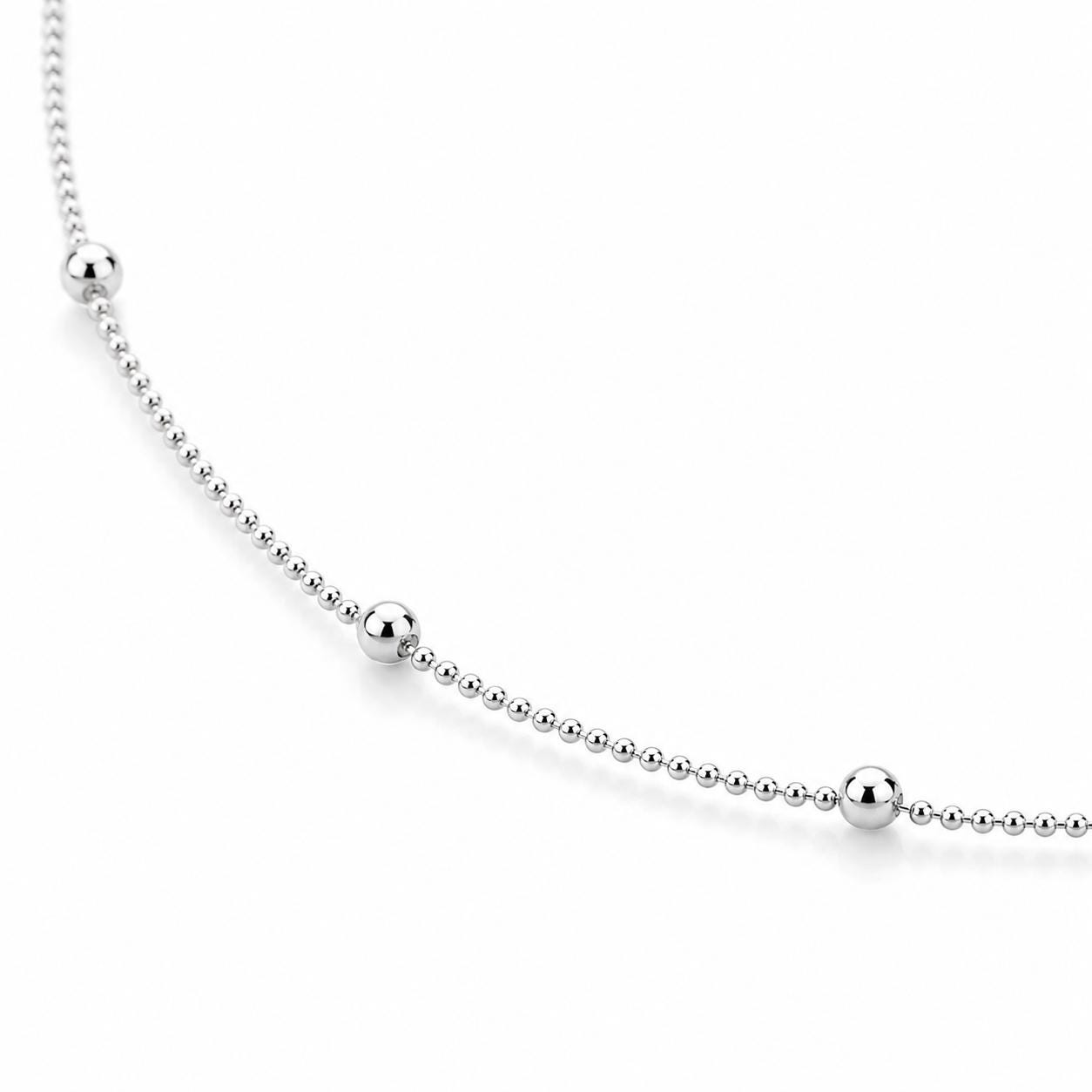 Close-up of polished platinum station beads spaced along the chain