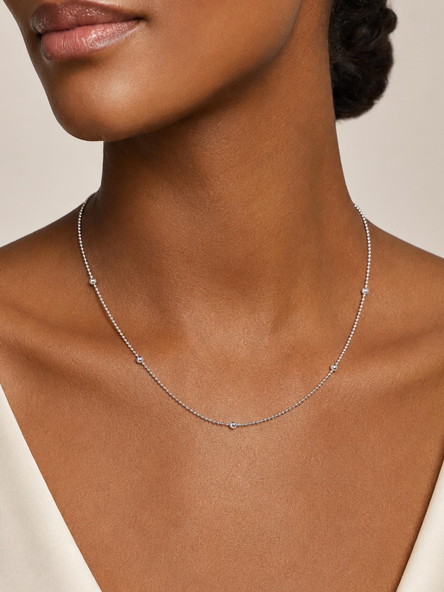 Close neckline view of PT950 platinum station necklace on dark skin