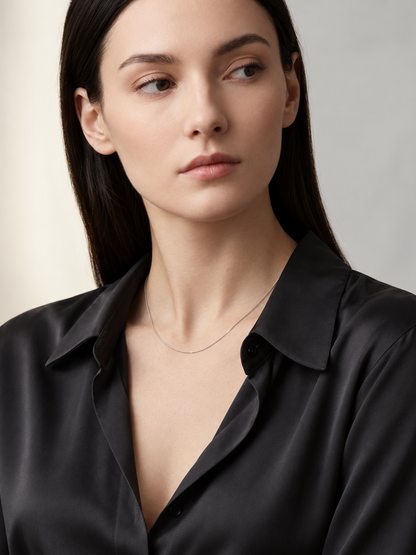 HELIOR Linea Fine platinum snake chain necklace worn with a black silk shirt.